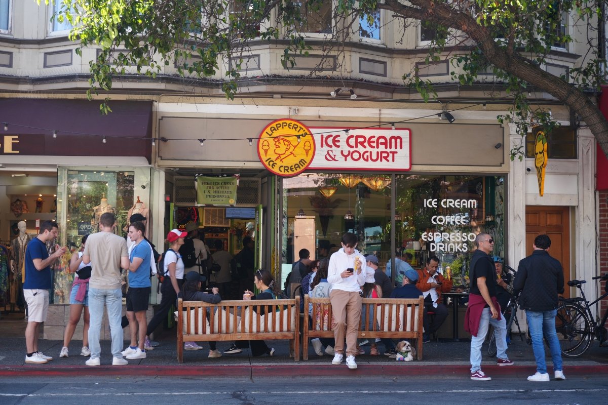Busy Lapperts Ice Cream & Yogurt shop storefront with wooden benches, customers enjoying treats, and people standing on sidewalk