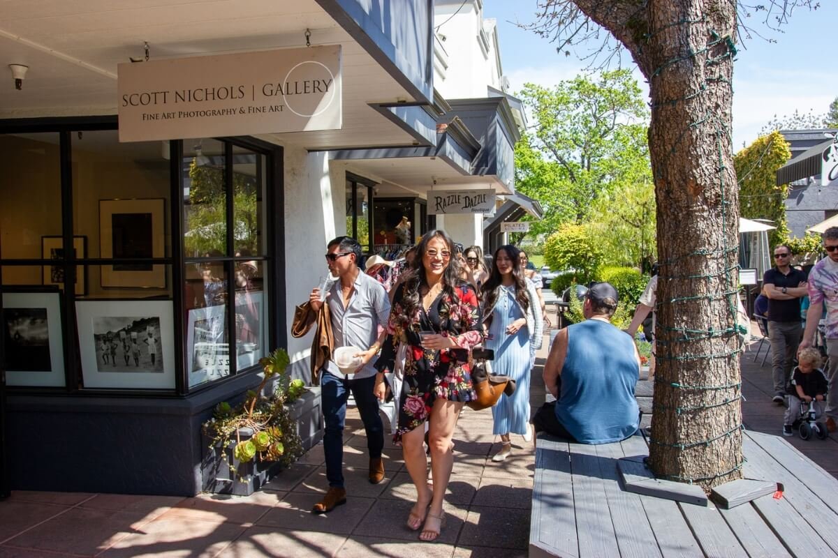 Visitors exploring Scott Nichols Gallery and boutique shops on a sunny day in wine country downtown district.