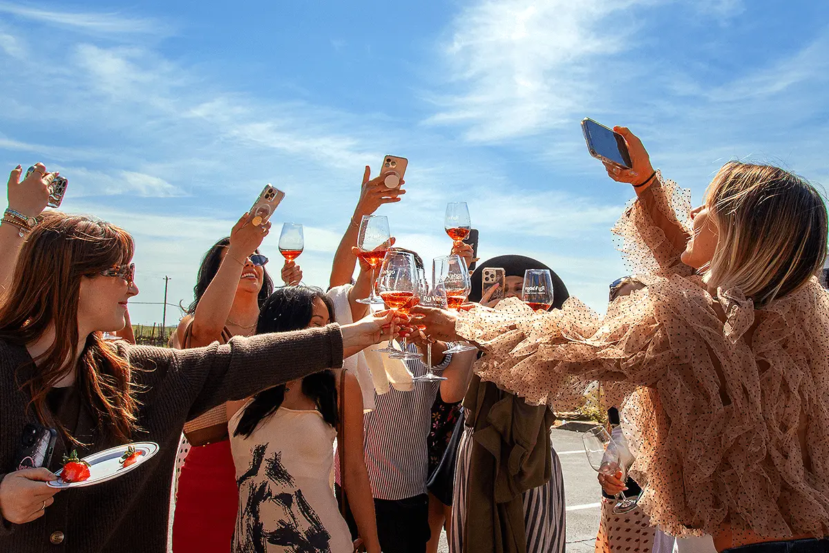 Group of women on a wine tour clinking glasses and toasting in Napa Valley.