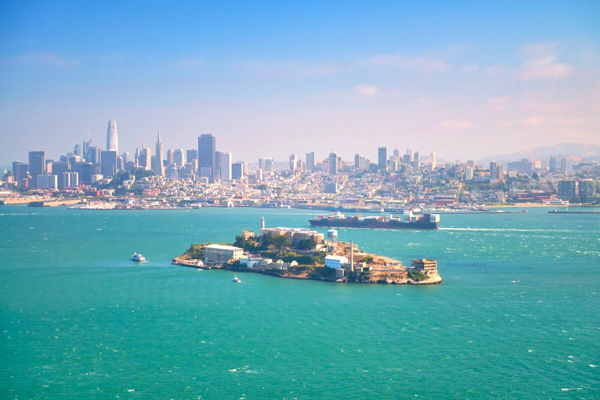 Alcatraz Island surrounded by San Francisco Bay with the city skyline visible in the background.