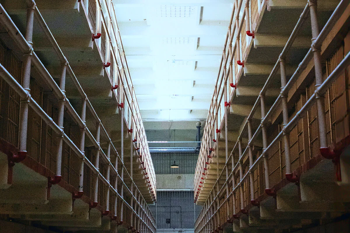 Interior of Alcatraz cellhouse showing long rows of prison cells and barred doors.