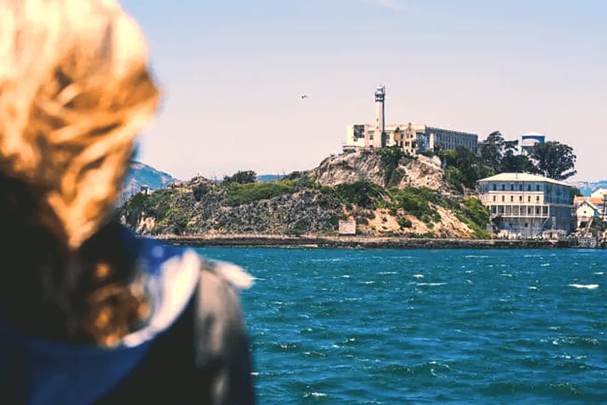 Visitor looking at Alcatraz Island from a ferry on San Francisco Bay